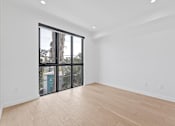 Thumbnail 49 of 119 - A room with a large window and sliding glass doors.