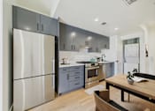 Thumbnail 24 of 157 - A modern kitchen with a wooden table and stainless steel appliances.