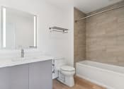 Thumbnail 147 of 163 - A white bathroom with a toilet, sink, and bathtub.