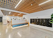 Thumbnail 25 of 119 - A reception area with a wooden ceiling and a white reception desk.