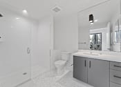Thumbnail 47 of 119 - A white bathroom with a toilet, sink, and shower.