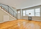 Thumbnail 15 of 24 - an empty living room with a staircase and a large window