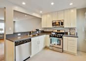 Thumbnail 12 of 24 - the kitchen has stainless steel appliances and white cabinets