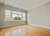Thumbnail 16 of 24 - an empty living room with wood floors and a window