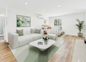 Thumbnail 9 of 32 - A living room with a white couch and a green rug.