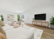 Thumbnail 3 of 28 - A living room with a white couch and a wooden coffee table.