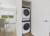 Thumbnail 5 of 28 - A modern laundry room with a washer and dryer built into the wall.