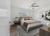 Thumbnail 6 of 28 - A bedroom with a bed, a bench, and a ceiling fan.