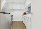 Thumbnail 9 of 32 - A kitchen with white cabinets and a stainless steel refrigerator.