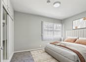 Thumbnail 13 of 32 - A bedroom with a large bed and a window with blinds.