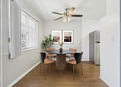 Thumbnail 10 of 32 - A dining room with a table and chairs.