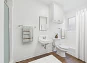 Thumbnail 15 of 32 - A white bathroom with a toilet, sink, and mirror.
