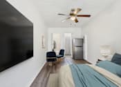 Thumbnail 1 of 19 - A bedroom with a bed, chair, and a ceiling fan.