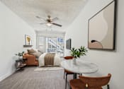 Thumbnail 5 of 19 - A living room with a brown chair and a white table.