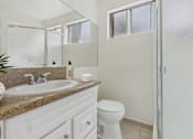 Thumbnail 15 of 61 - A bathroom with a sink, toilet, and a mirror.