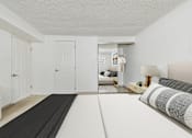 Thumbnail 13 of 61 - A bedroom with a bed, nightstand, and a yoga mat on the floor.