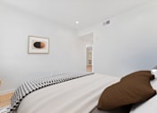 Thumbnail 52 of 157 - A bed with a brown pillow and a striped blanket.