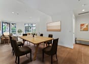 Thumbnail 48 of 157 - A dining room with a wooden table and chairs.