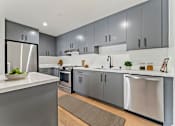 Thumbnail 45 of 157 - A modern kitchen with stainless steel appliances and grey cabinets.