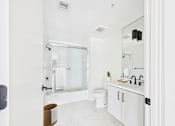 Thumbnail 44 of 157 - A white bathroom with a toilet, sink, and mirror.