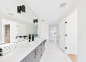 Thumbnail 43 of 157 - A bathroom with a white counter top and a white sink.