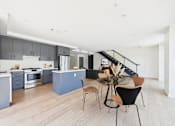 Thumbnail 34 of 157 - A modern kitchen with a dining table and chairs.