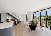 Thumbnail 32 of 157 - A modern kitchen with a dining table and chairs.