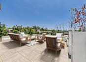 Thumbnail 38 of 157 - A patio with wooden furniture and a view of the city.