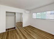 Thumbnail 10 of 14 - A room with wooden floors and a window with blinds.