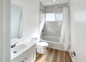 Thumbnail 14 of 14 - A white bathroom with a toilet, sink, and shower.
