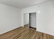 Thumbnail 5 of 14 - A room with a wooden floor and a white door.