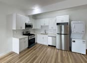Thumbnail 6 of 14 - A kitchen with white cabinets and stainless steel appliances.