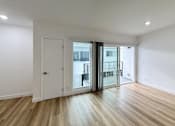 Thumbnail 8 of 14 - A room with a white door and a balcony with a black railing.