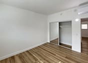 Thumbnail 13 of 14 - A room with a white wall and a wooden floor.