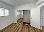 Thumbnail 12 of 14 - A room with a wooden floor and a white door.