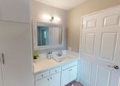 Thumbnail 34 of 34 - A white bathroom with a sink and mirror.