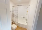 Thumbnail 33 of 34 - A white bathroom with a toilet and a shower.