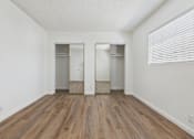 Thumbnail 20 of 22 - A room with a wooden floor and two closets.