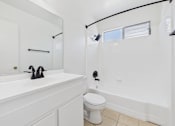 Thumbnail 22 of 22 - A white bathroom with a toilet, sink, and mirror.