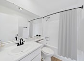 Thumbnail 5 of 38 - A white bathroom with a sink, toilet, and shower.