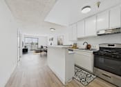 Thumbnail 1 of 38 - A kitchen with a white counter and a black stove.