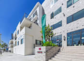 Thumbnail 11 of 33 - A white building with a green flag in front of it.