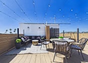 Thumbnail 26 of 33 - A patio with a table and chairs is set up on a wooden deck.
