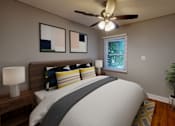Thumbnail 19 of 21 - A bedroom with a bed, pillows, a ceiling fan, a nightstand, a lamp, a plant, and a window.