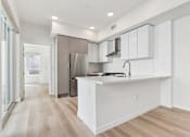 Thumbnail 131 of 163 - A kitchen with white cabinets and a wooden floor.