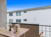 Thumbnail 6 of 18 - a table on a balcony with a building in the background