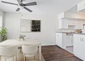 Thumbnail 3 of 18 - a kitchen and dining room with white cabinets and a ceiling fan