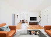 Thumbnail 3 of 24 - A living room with a brown couch and a coffee table.