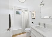 Thumbnail 10 of 19 - A white bathroom with a toilet, sink, and shower.