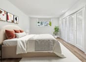 Thumbnail 8 of 29 - A bedroom with a bed, pillows, and a plant.